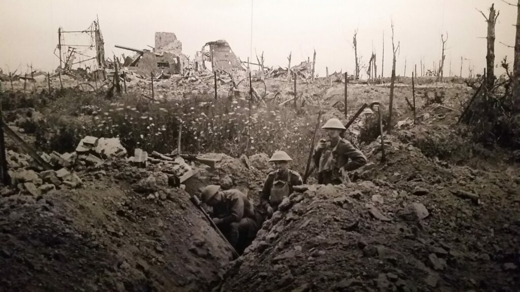 A black and white picture of three soldiers in a world war 1 trench with debris around them